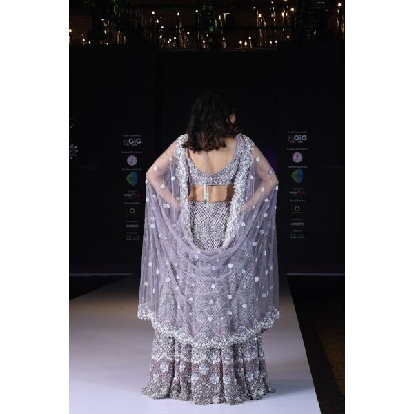 A lavender pewter lehenga richly embroidered with cutwork in Zari and stonework , with a matched net dupatta with a heavy border and fully embroidered blouse.